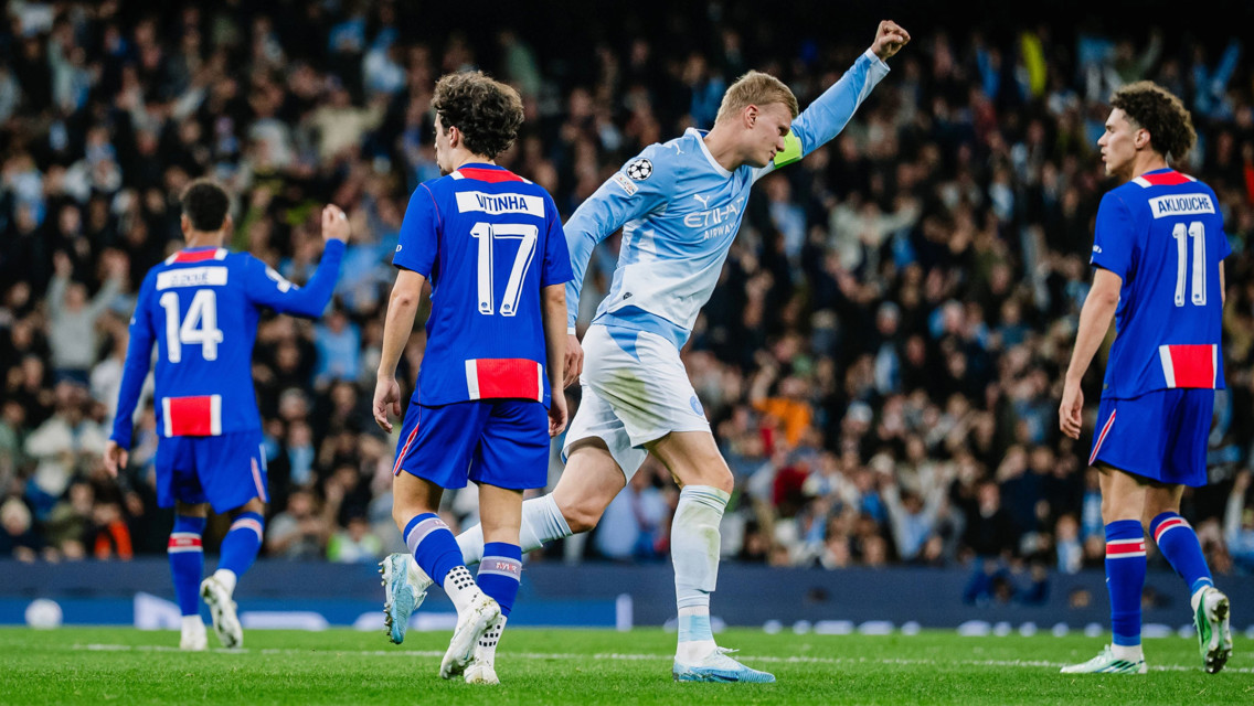 Soccer match between Manchester City in blue and white kit and FC Copenhagen in blue kit. Players include numbers 14, 17, and 11 from Copenhagen and a Manchester City player celebrating with raised arm.