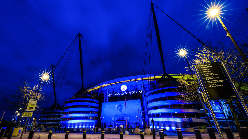 NHS TRIBUTE : The Etihad Stadium is lit up in blue to mark one year since the UK Covid-19 lockdown began, 23rd March 2021.