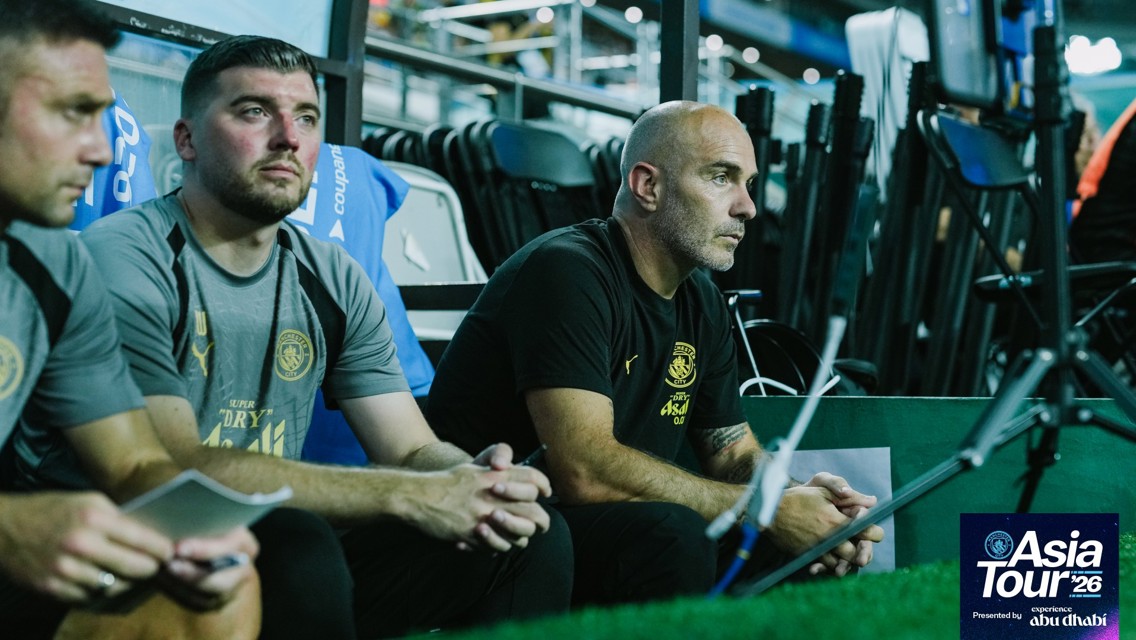 Coaching staff on the bench during Manchester City's Asia Tour '26, presented by Experience Abu Dhabi.