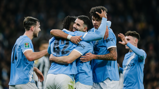 Manchester City players in blue jerseys celebrating a goal during a match.
