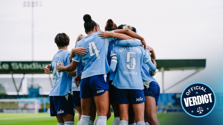 A group of female football players huddling in celebration wearing light blue jerseys numbered 4, 5, and 20. Text overlay reads 'Official Verdict.'