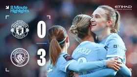Manchester City Women's team celebrates a 3-0 victory over Manchester United, with team members embracing on the field.