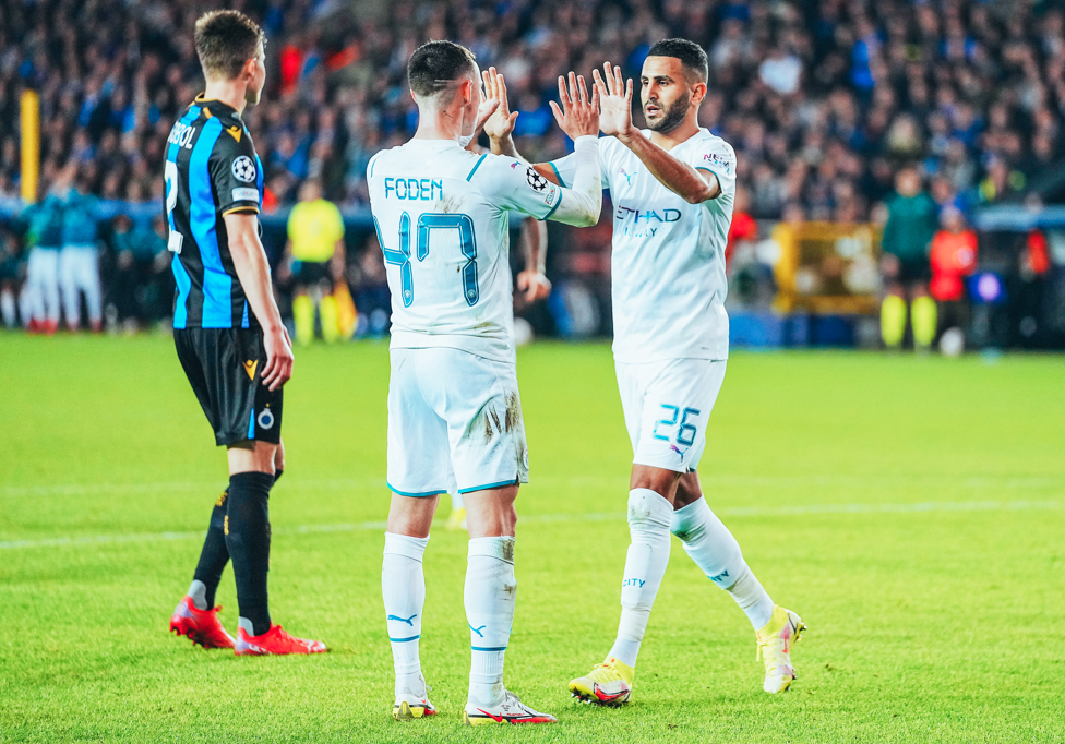 Foden e Mahrez celebram gol contra o Brugge. 