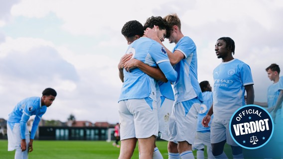 Youth team in light blue jerseys celebrating a goal during a football match. Players are hugging and express joy. 'Official Verdict' badge displayed with Etihad Airways logo.