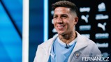 A person wearing a Manchester City jacket is smiling in front of a background with Puma and Manchester City logos. The text 'Welcome to City Enzo Fernandez' is visible.