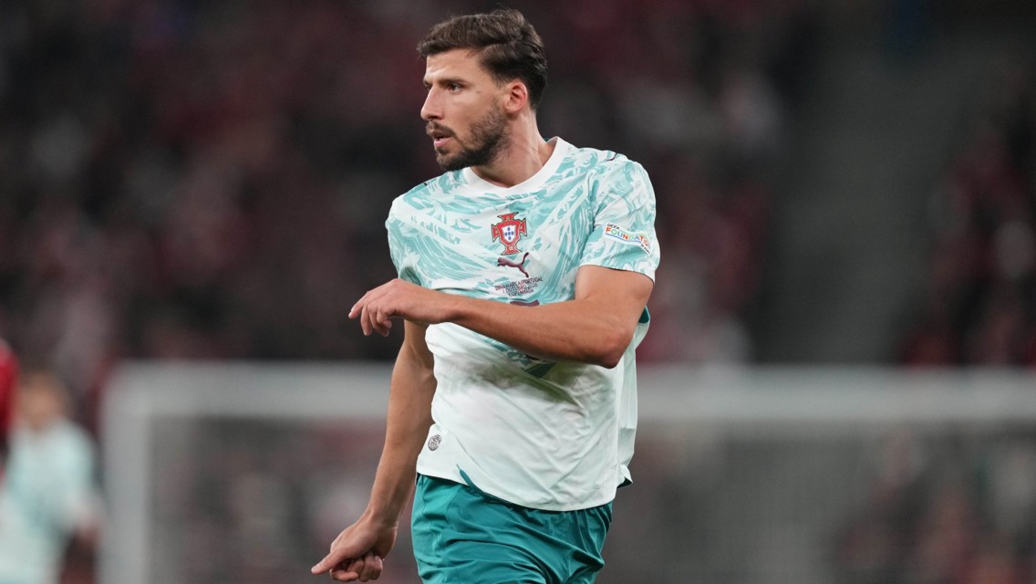 Soccer player in Portugal team kit during a match on the field.