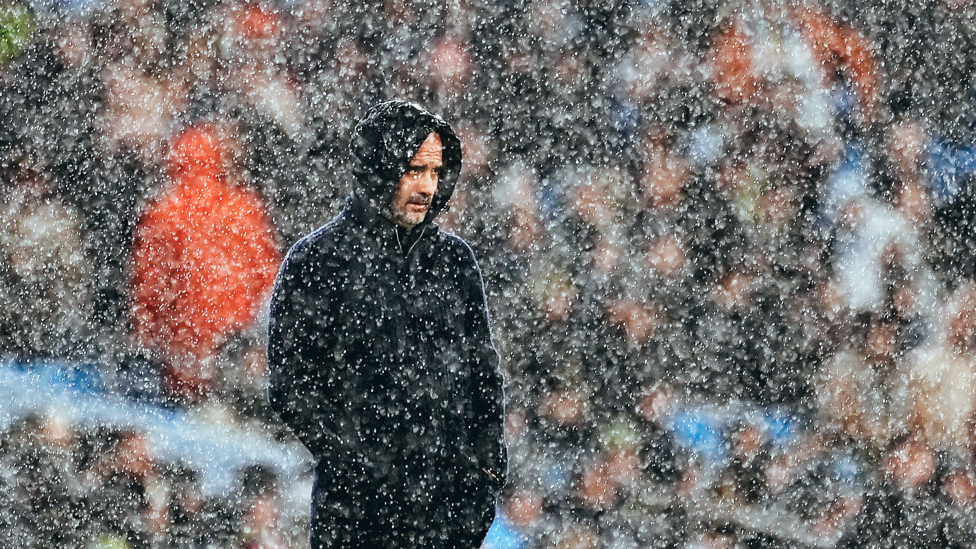 RAIN ON ME : The boss feels the full force of the Manchester weather.