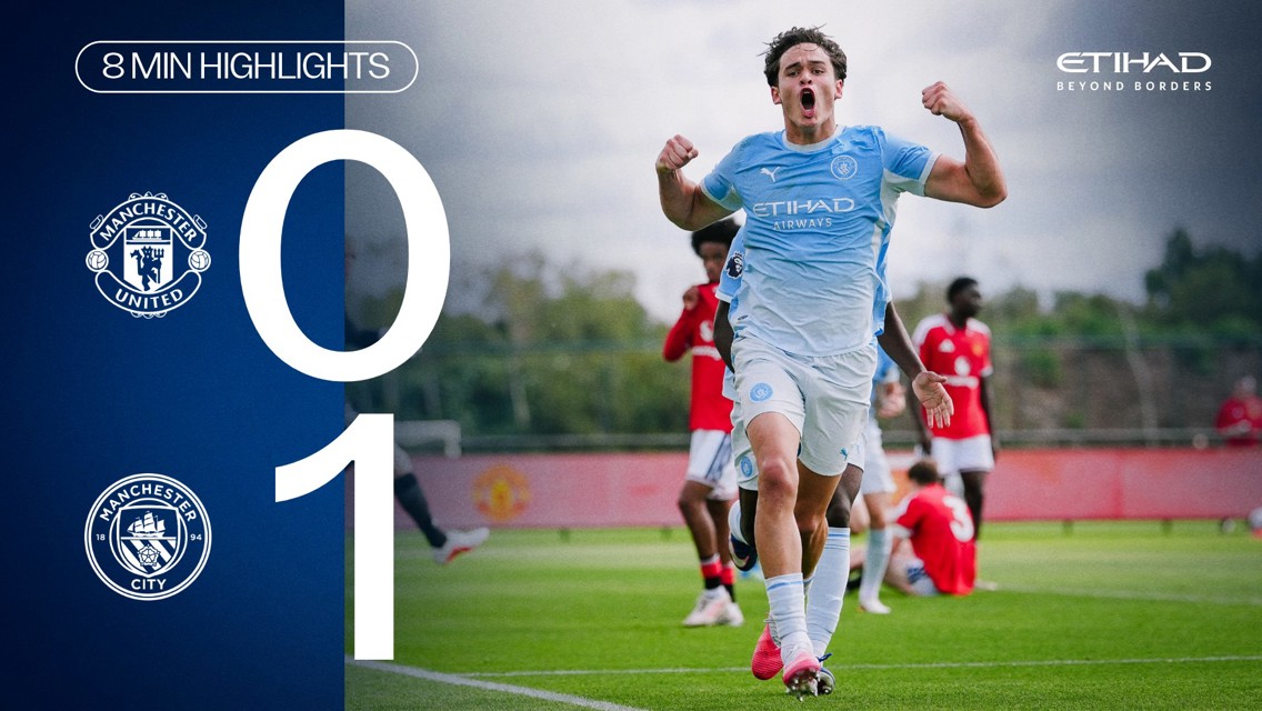 Manchester City player celebrating after a 1-0 victory against Manchester United. Emblems of both clubs are shown.