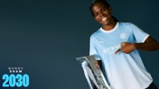 A person in a Manchester City football kit holding a shiny trophy with the text 'Bunny Shaw 2030'.