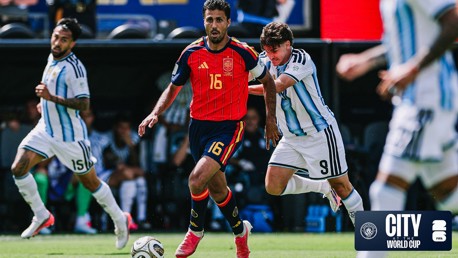Football match action between players in Spain and Argentina kits with a World Cup logo.