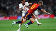 Two players from England and Spain competing in a match. The English player wears a white jersey with number 3, and the Spanish player wears red with number 10.