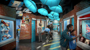 Museum exhibit featuring Manchester City football club items, blue umbrellas, posters, and visitors with children.