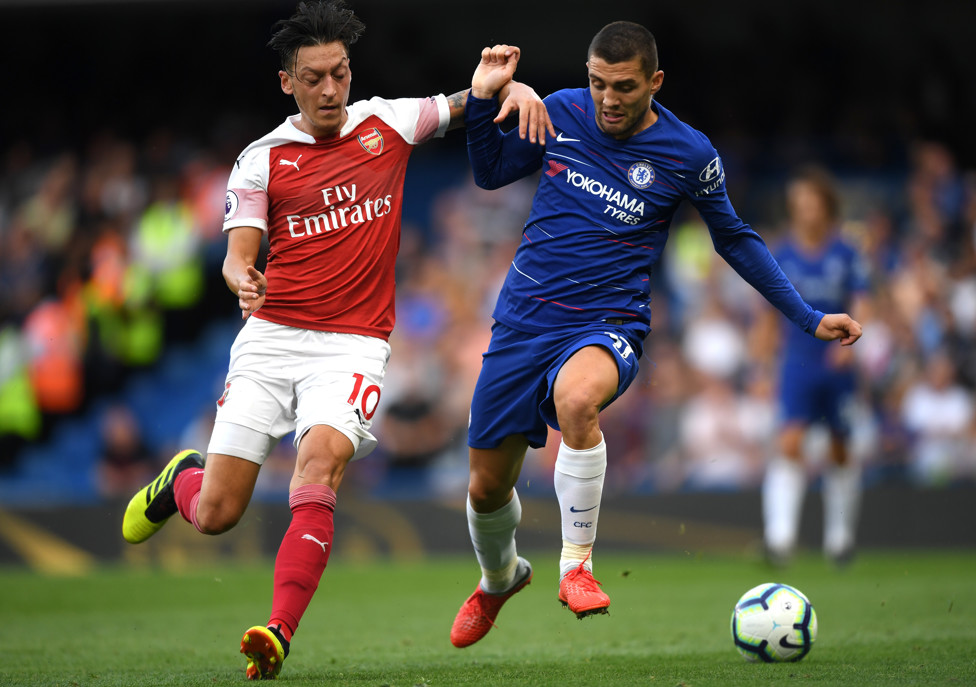 WELCOME TO ENGLAND : Kovacic goes head-to-head with Mesut Ozil in his first Premier League game in Chelsea colours