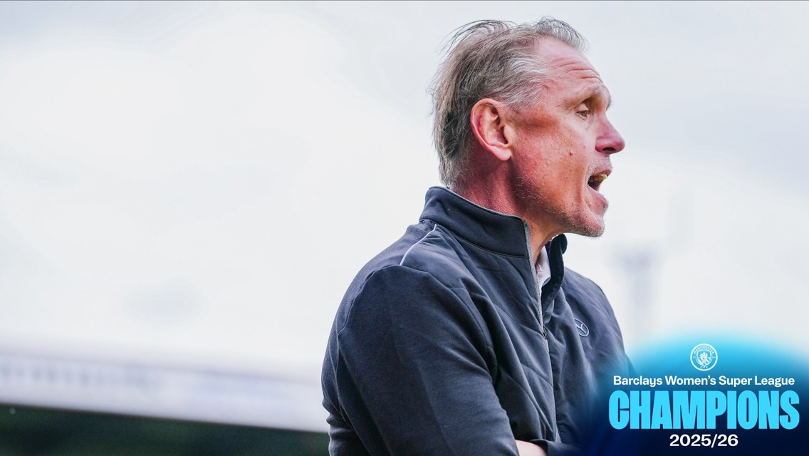 A person in a dark jacket with a blurred face stands in front of a backdrop indicating Barclays Women's Super League Champions 2025/26.