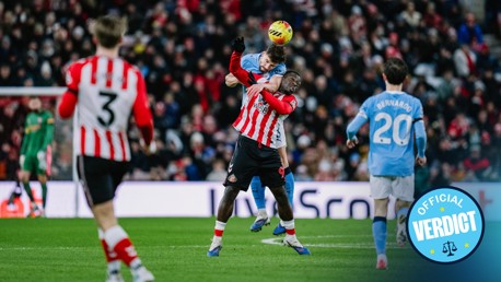 Soccer players in action with a header attempt, two players in red and white stripes and a player in blue. Official Verdict logo in the bottom right corner.