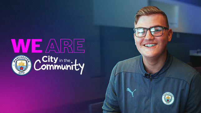 A Manchester City promotional image with the text 'We Are City in the Community' and the Manchester City logo. The image also features a person wearing a Manchester City branded Puma tracksuit.