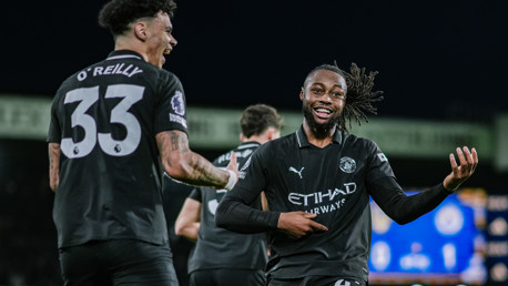 Two Manchester City players celebrating on the field, one with the jersey number 33 and the other number 42.