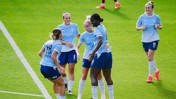 Manchester City Women players celebrating on the field wearing light blue jerseys with Etihad Airways logo.