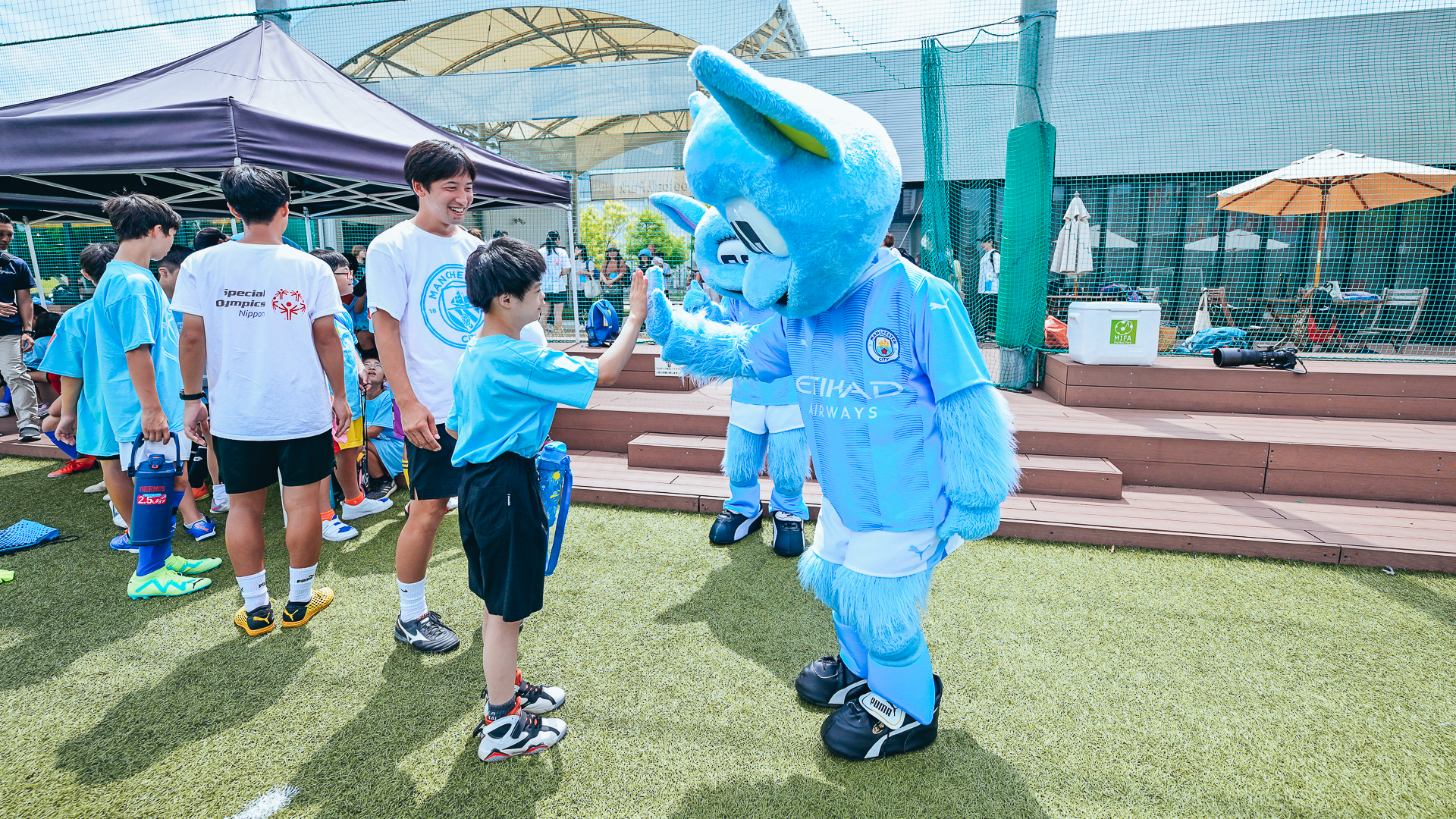 HAND IT TO MOONCHESTER: Our mascot shares greetings with a local youngster.