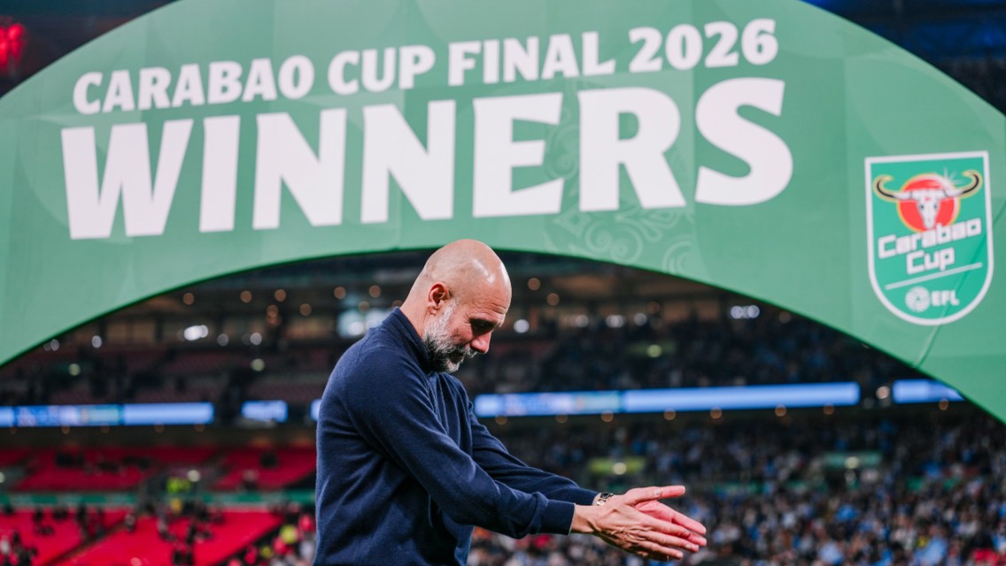 A person applauding under a large green banner that reads 'Carabao Cup Final 2026 Winners'. The Carabao Cup logo is featured on the banner.