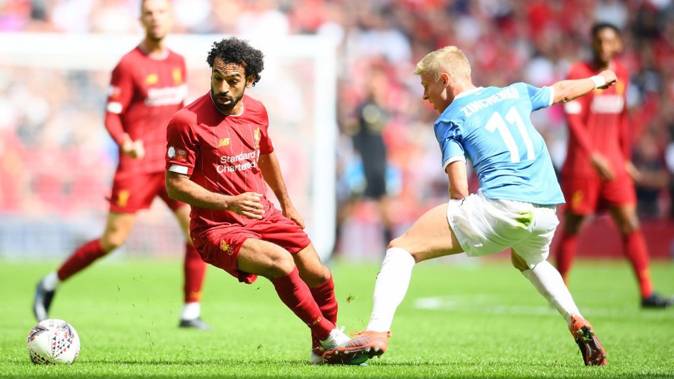 HANDFUL : Oleksandr Zinchenko keeps a close eye on Mo Salah.