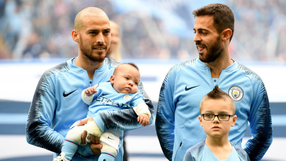 LITTLE BOY BLUE: David Silva cradles his son Mateo before kick-off
