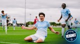 A Manchester City player celebrates a goal by sliding on the field, wearing the light blue kit. Teammates run towards him in the background. The image features a logo reading 'Official Verdict'.