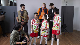 Children wearing Kellogg's sponsored football kits with adults behind them, possibly during a photo shoot or event.