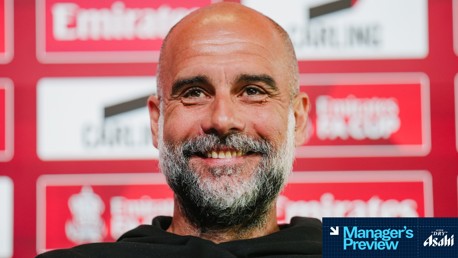 Blurred face at a press conference backdrop mentioning 'Emirates FA Cup'.