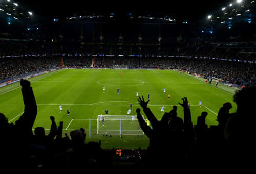 A view behind Manchester City fans celebrating a goal on matchday at the Etihad Stadium.