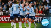 Manchester City women's football team celebrates a goal on the field. Players in light blue jerseys are cheering and clapping.