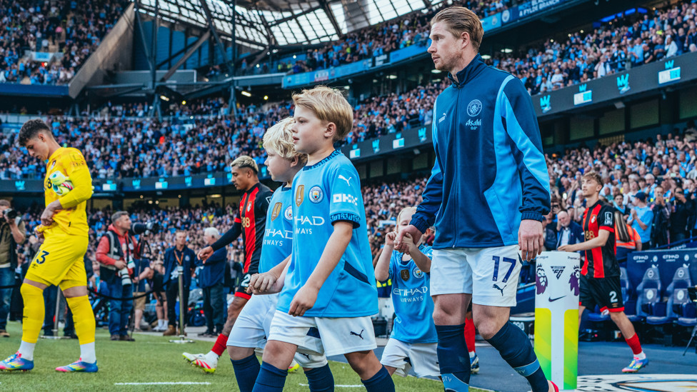 SKIPPER : KDB leads the team out with his children.