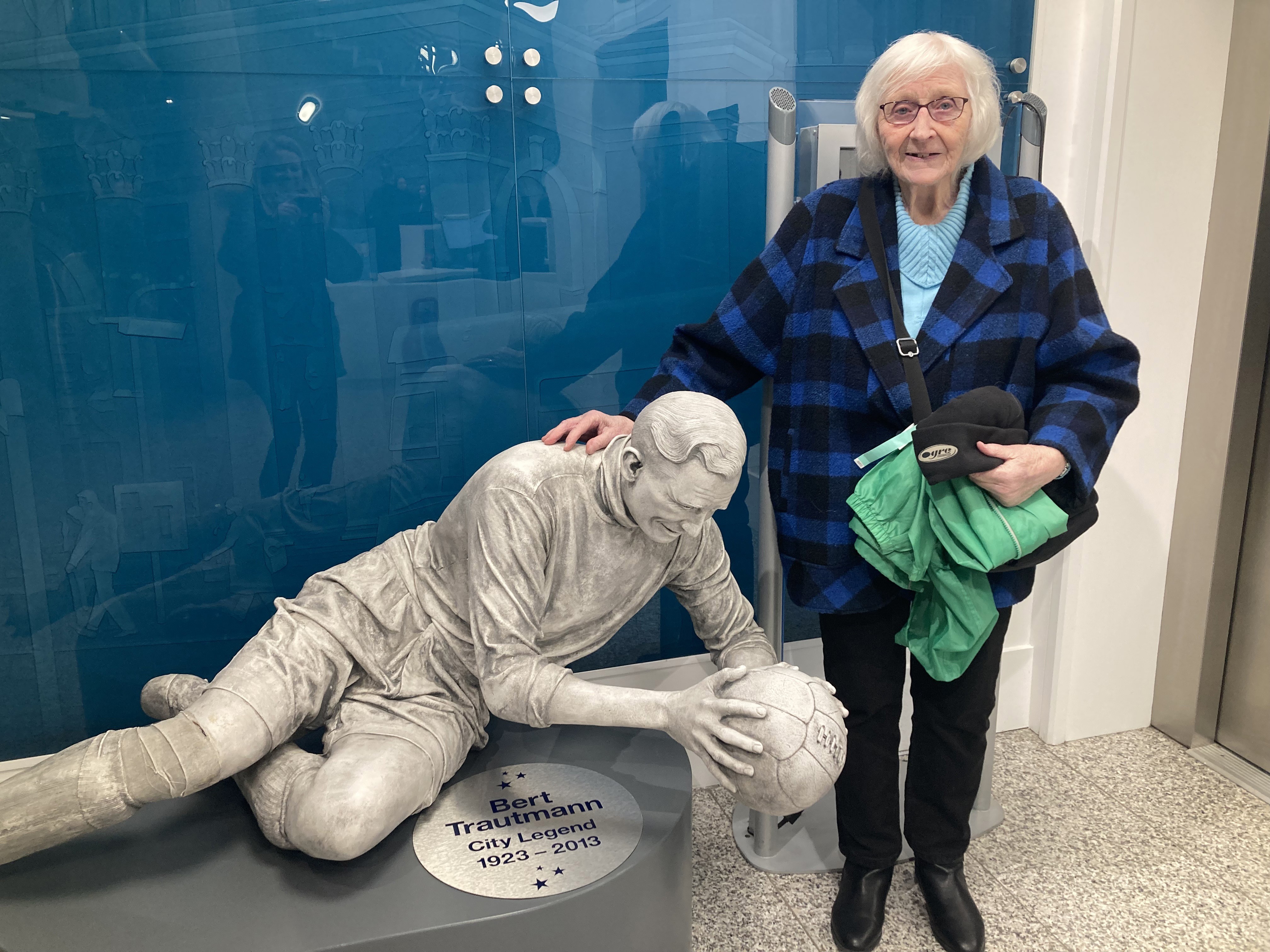 ETIHAD DERBY : Mary Bee pictured with the statue of Bert Trautmann in January 2025