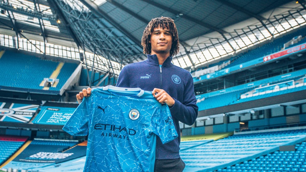 NEW MAN ABOUT TOWN : Ake holds up the City shirt after his move to the Etihad is complete