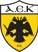 Logo of AEK FC with a black double-headed eagle on a yellow shield and 'AEK F.C.' text at the bottom.