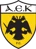Logo of AEK FC with a black double-headed eagle on a yellow shield and 'AEK F.C.' text at the bottom.