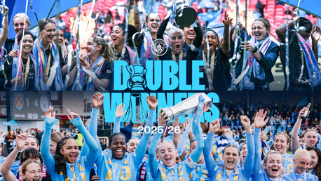 Manchester City celebrates winning two titles in the 2025/26 season with players lifting the trophies. The image includes banners and blurred faces with the text 'Double Winners' prominently displayed.