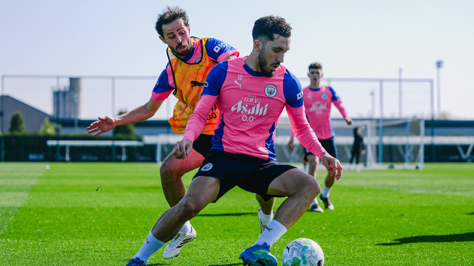 MIDFIELD BATTLE  : Rayan Cherki shields the ball from Bernardo. 