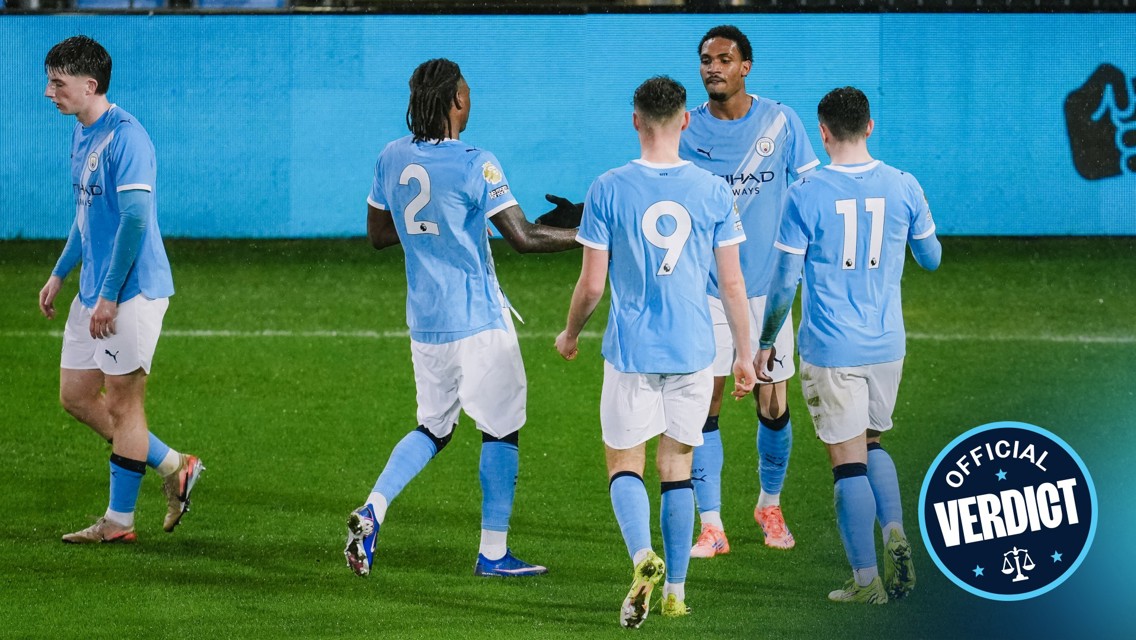 Manchester City players celebrating on the field wearing light blue jerseys with player numbers visible.