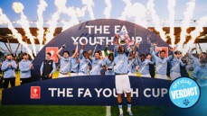 Football team celebrating their victory in the FA Youth Cup with fireworks and trophy.