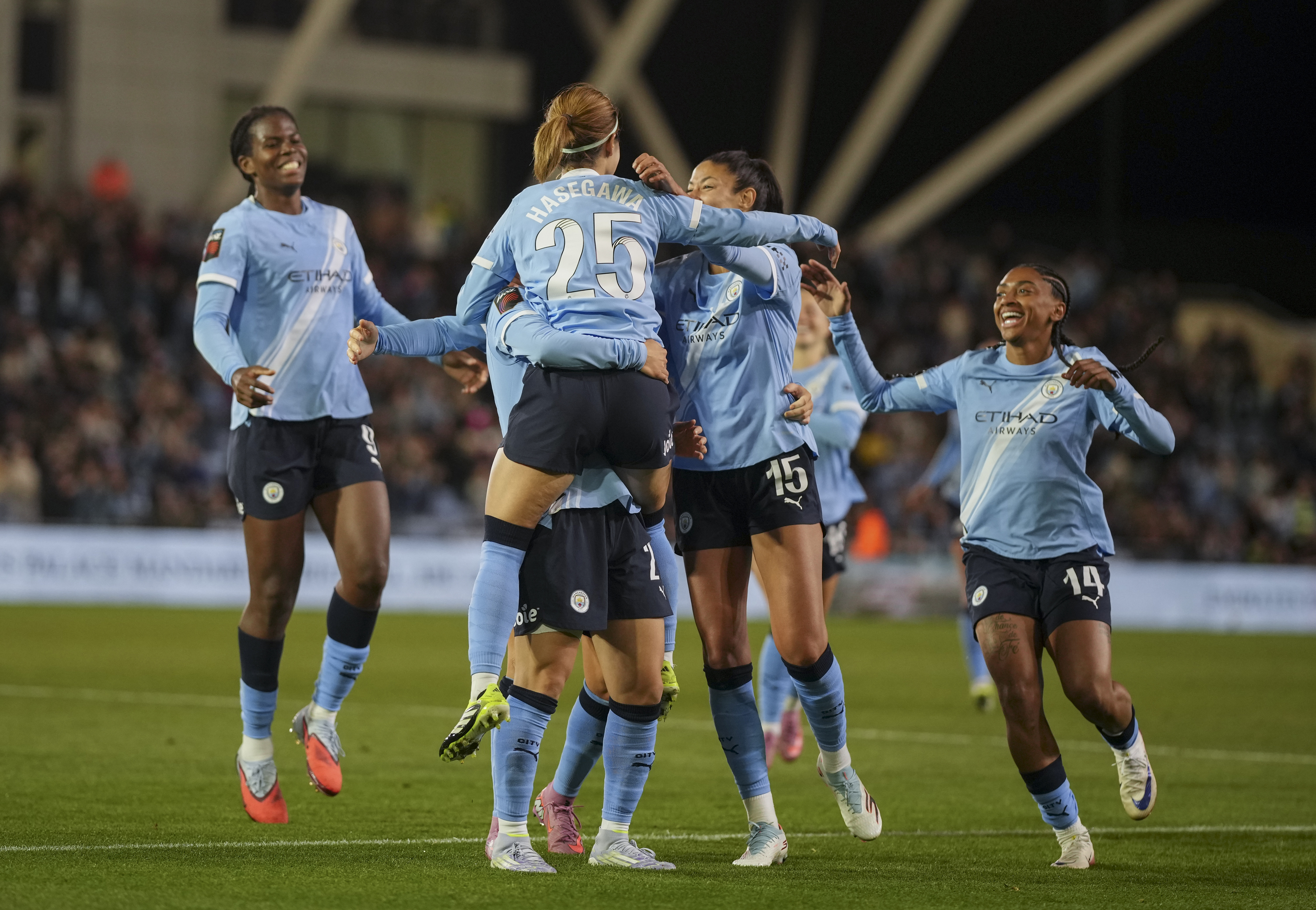 Manchester City Women's football team players celebrating a goal, one player visible with jersey number 25.