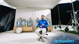 A person sits in a chair surrounded by football trophies, including Premier League and UEFA Champions League trophies. The text reads 'Thank You Bernardo' with years 2017 to 2026.