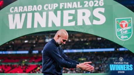 A person clapping in front of a large sign reading 'Carabao Cup Final 2026 Winners'.
