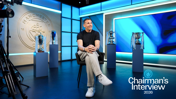 A person is seated in front of several trophies with the Manchester City logo on the wall. Text reads 'Chairman's Interview 2026'.