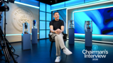 A person is seated in front of several trophies with the Manchester City logo on the wall. Text reads 'Chairman's Interview 2026'.