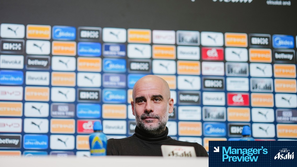 A person at a press conference with a blurred face, seated in front of a backdrop featuring various logos such as Puma, Etihad, and Asahi. The text 'Manager's Preview' is visible.