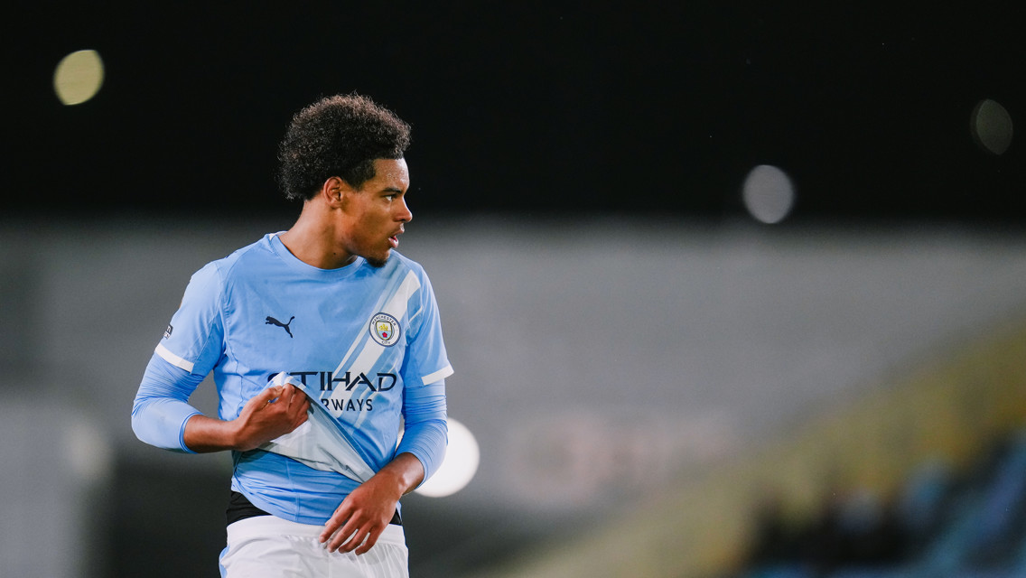 A Manchester City player wearing the team's kit during a match, with a blurred facial area.