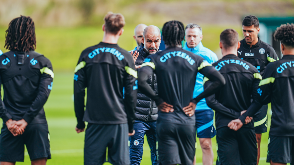 'Listen up...'  Pep gets the players together....
