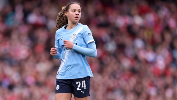 A soccer player wearing a Manchester City Women jersey with the number 24 on the field.
