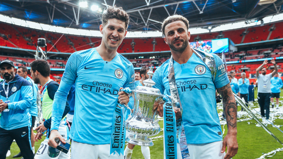 SILVERWARE : Walker and Stones pictured with the FA Cup trophy after City’s 6-0 win over Watford in 2018/19. 